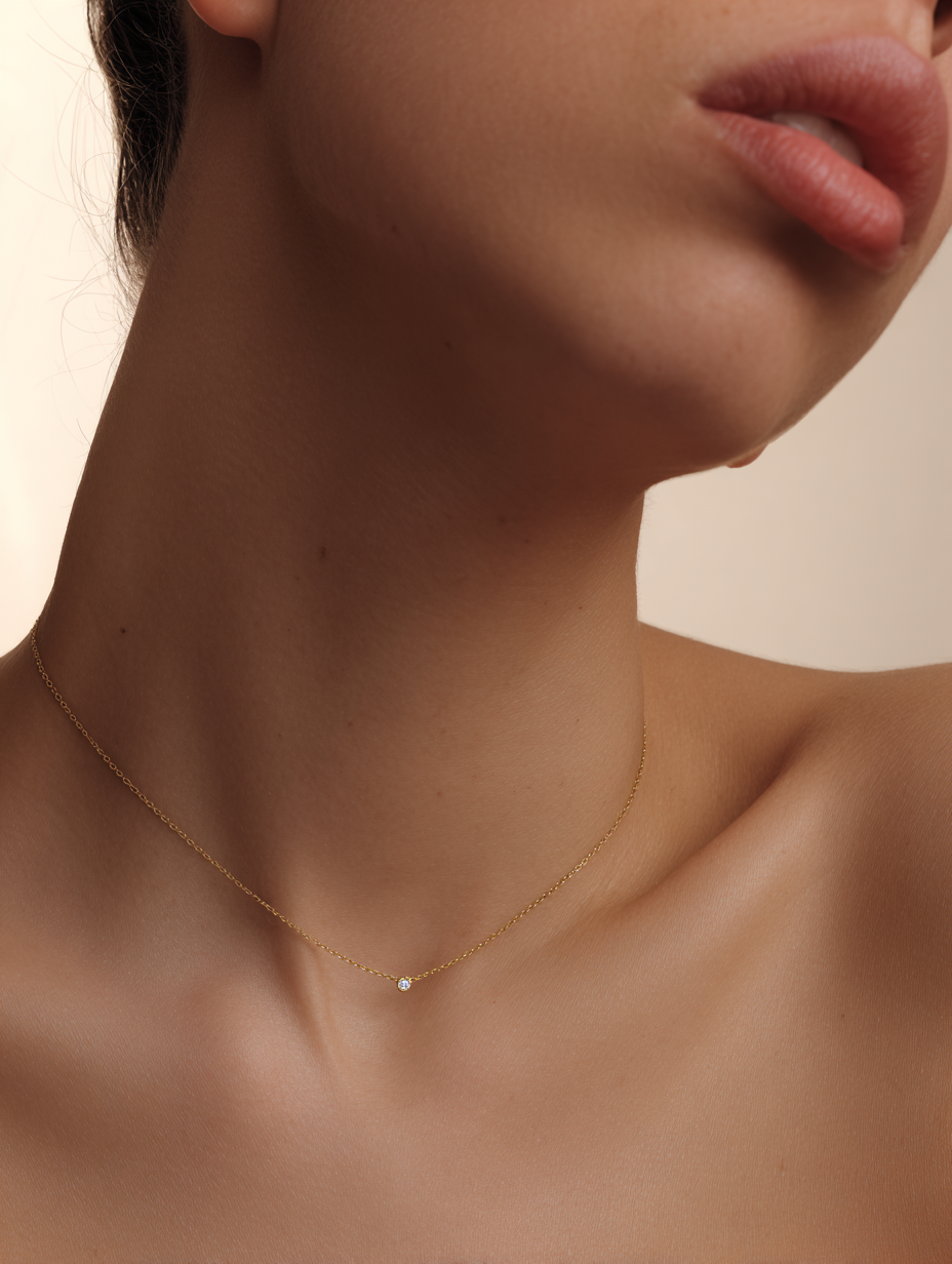 girl wearing a fine gold necklace with a bezel set diamond looking to the left